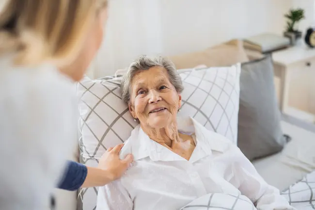 Elderly woman smiling with caretaker